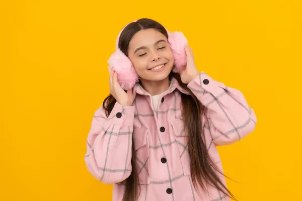 Melegség megérinteni. A boldog gyermek élvezi a szőrmés fülvédőt. Divat téli kiegészítők — Stock Fotó