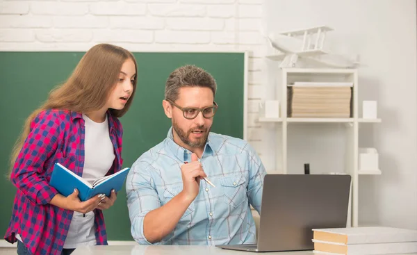 Drukke student en mentor met laptop. Vader en tienermeisje studeren. privéleraar en -kind — Stockfoto