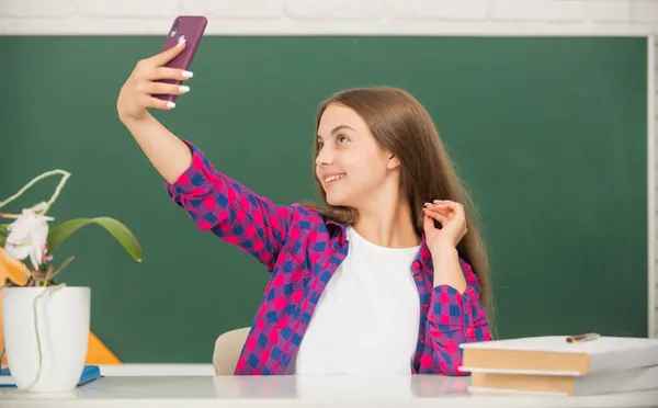 快乐的孩子自作主张。学校博客。在教室里带手机的vlogger. — 图库照片
