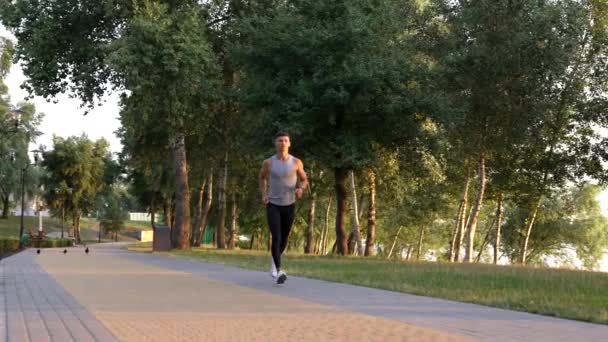 Course matinale de l'athlète homme courant dans le parc, exercice aérobie — Video