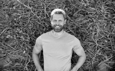 Sakallı olgun bir adam. Mutlu, tıraşsız, doğal bir geçmişi olan adam..