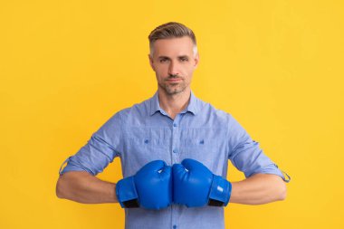 Sarı arka planda boks eldivenli adam, başarı.
