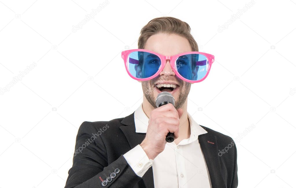 Portrait of happy professional man in funny glasses and formal suit speaking to microphone, showman