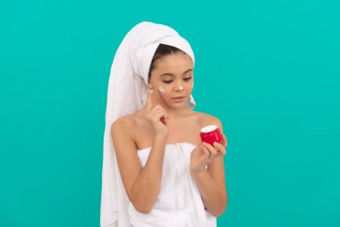 Banyo kulesinde genç bir çocuk cilt kremi sürüyor.