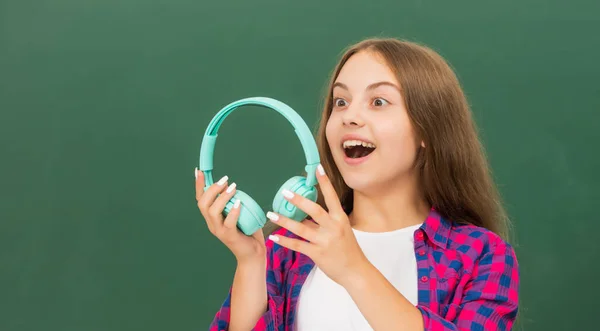 Chica adolescente sorprendida en los auriculares. amante de la música. escuchar música. accesorio de dispositivo de auriculares inalámbricos. — Foto de Stock