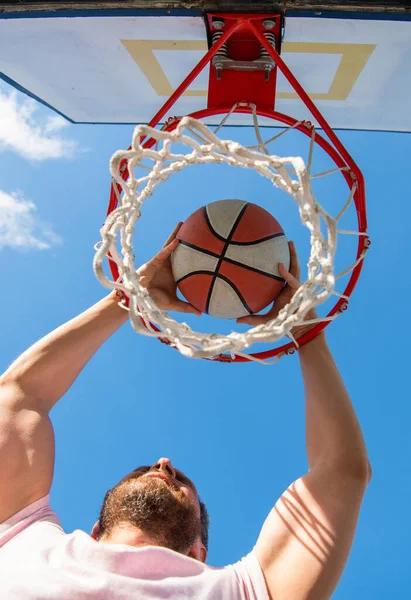 Homem dunking bola de basquete através de anel líquido com as mãos, sucesso — Fotografia de Stock