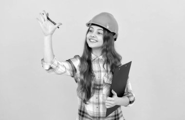 Gelecekteki kariyerim. Kasklı genç kız notlar alıyor. İnşaatçı çocuk klasöre yazıyor..
