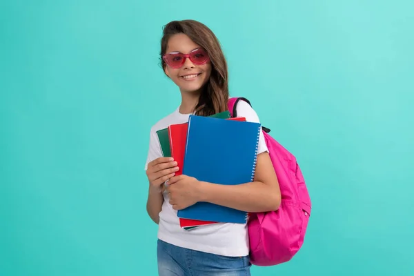 Szczęśliwy dzieciak z plecakiem i copybook w okularach przeciwsłonecznych gotowy do nauki w szkole, wiedza — Zdjęcie stockowe