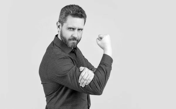 Mature man bend arm in L-shape with fist pointing upwards obscene gesture grey background, fuck you — Stock Fotó