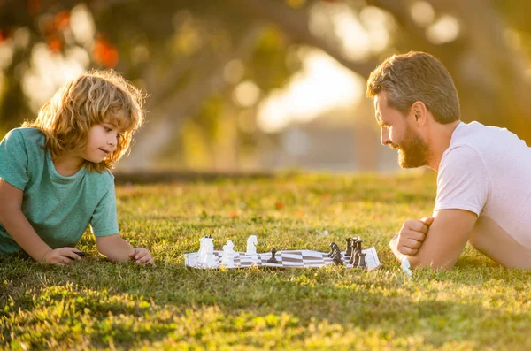 Pai e filho jogando xadrez no parque da manhã. Dia dos pais. família feliz. parentalidade — Fotografia de Stock