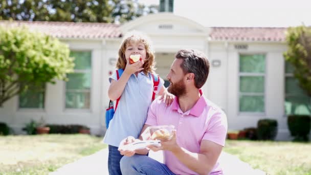 Heureux père et fils manger de la nourriture après l'école, ralenti, première année — Video