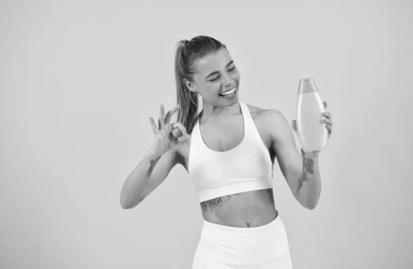 Mujer feliz presentación botella de acondicionador de champú para el cabello o loción corporal para el cuidado de la piel y el baño, ok — Foto de Stock