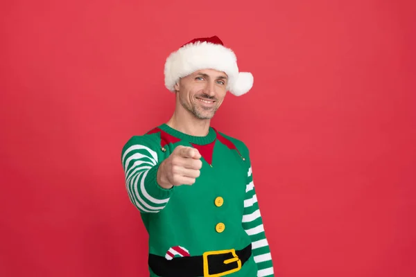 Hombre feliz disfrazado de elfo. chico de Navidad en sombrero de Santa Claus sobre fondo rojo. feliz año nuevo. —  Fotos de Stock