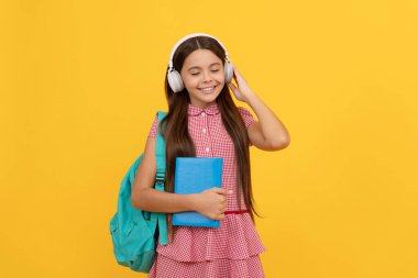 Okul çantalı neşeli çocuk. Müzik. Genç kız sırt çantası taşıyor. Okula geri dön..