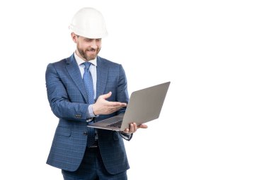 Bilgisayar teknolojisine adapte oluyorum. İnşaat mühendisi hesaplama yapıyor. Sert şapkalı profesyonel adam dizüstü bilgisayar kullanıyor.