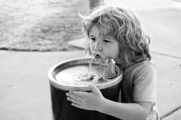 Verfrissingsoplossing. Dorstig kind drinkt water uit drinkfontein. Dorst lessen — Stockfoto