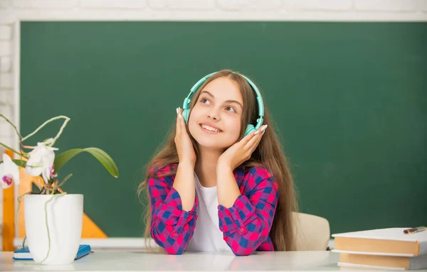 최신 이어폰을 끼고 웃는아이. 온라인 교육. 다시 학교로. 헤드폰을 쓴 십 대 소녀. — 스톡 사진