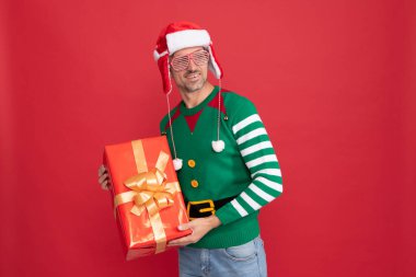 Mutlu yıllar. Mutlu noel hediyeleri. Gülümseyen elf kulaklı Noel Baba şapkalı adam..