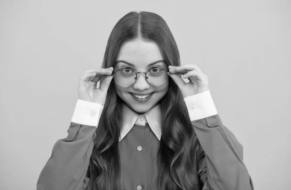 Happy school leeftijd meisje kind fix bril geel achtergrond, gezichtsvermogen — Stockfoto