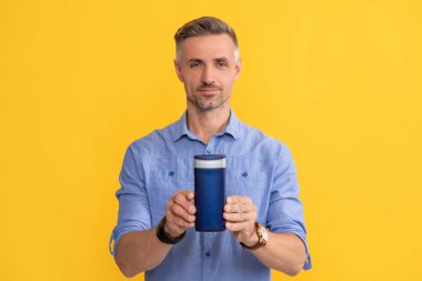 Erkekler için kozmetik ürünler sunuyorum. Duş jeli gösteren adam.