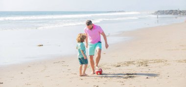 Spor aktivitesi. İyi ki baba oğul sahilde futbol oynuyorlar. Baba ve çocuk yaz günü.