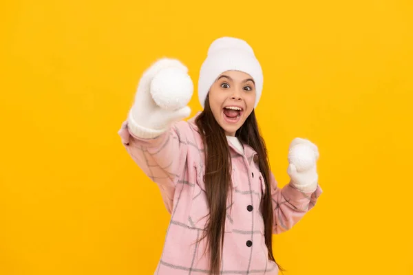 雪玉をやってる。冬の活動。帽子の子供を驚かせた。10代の女の子でミトンで装飾ボール — ストック写真