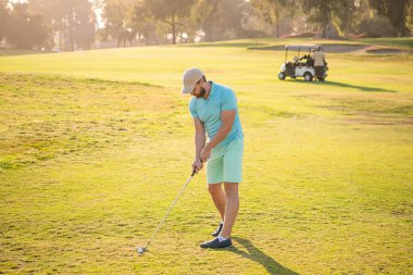 Profesyonel golf sahasında erkek golfçü. Golf sopasıyla şapkalı golfçünün portresi..