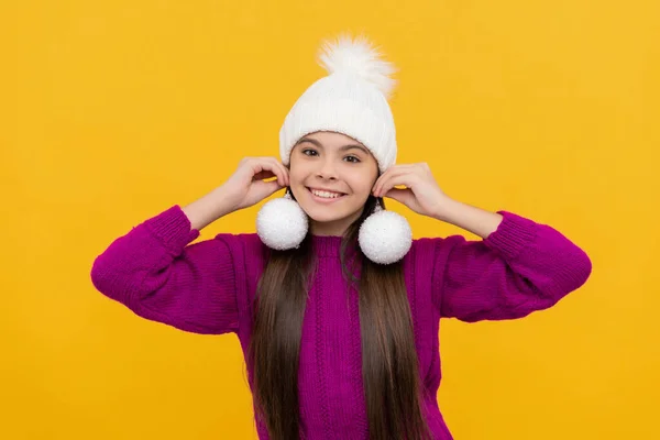 Cheerful kid in hat with snowballs on yellow background, christmas — Stock Photo, Image