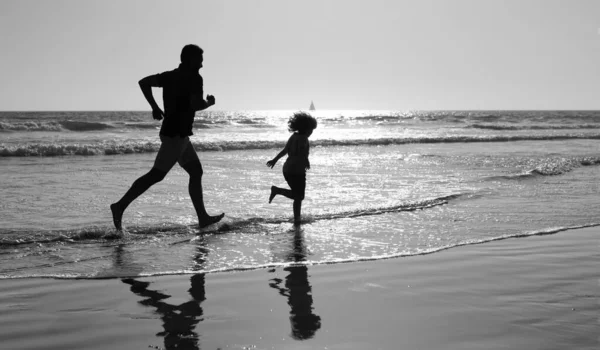 Papi con silueta de niño en el mar o el océano. fin de semana en familia. papá y el niño se divierten — Foto de Stock