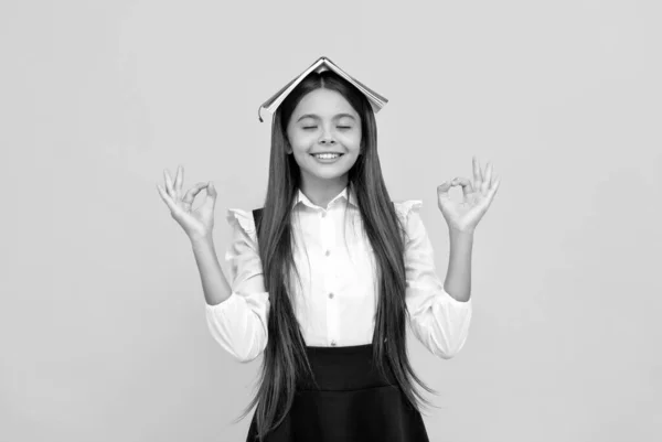 Wijsheid en eruditie. Gelukkig tienermeisje met boek op haar hoofd. Nerd mediteert. terug naar school. — Stockfoto