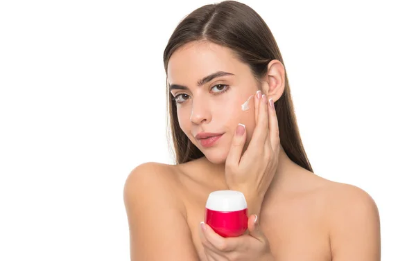 Giovane donna che applica crema per la pelle del viso isolata su sfondo bianco, abitudine quotidiana — Foto Stock