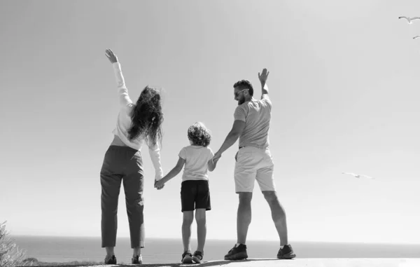 Família de mãe pai e filho menino olhando no futuro de mãos dadas no verão, visão traseira, adoção — Fotografia de Stock