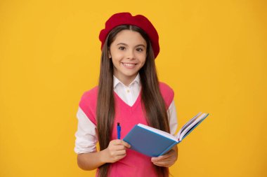 Fransız bereli mutlu liseli kız not defterine ya da defterine, okula not tutuyor.