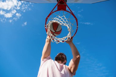 Profesyonel basketbolcu dışarıda antrenman yapıyor. Adamın spor motivasyonu var. spor ve hobi