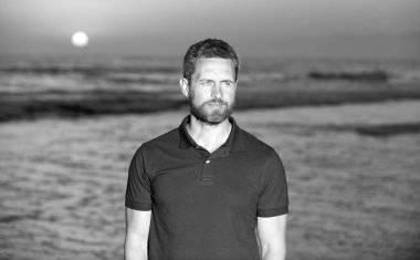 Sahildeki traşsız adam. Gündoğumu plajındaki beyaz adam. Gömlekli sakallı adam..