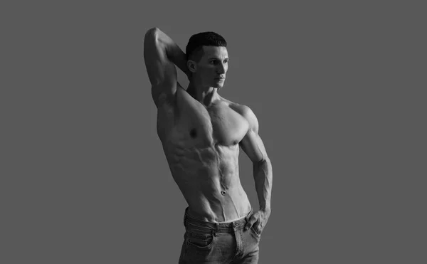 Pasujący facet z sześciopakiem mięśni brzucha pozował bez koszulki szarym tłem, mięśnie — Zdjęcie stockowe