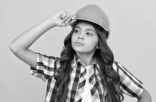 Serieus meisje met beschermende harde hoed. kinderen dragen een helm om te bouwen. bescherming en veiligheid. — Stockfoto