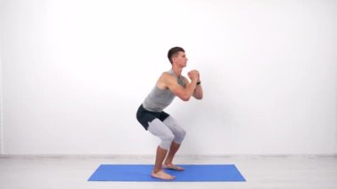 fitness paspası, beyaz arka plan, spor eğitimi üzerine çömelme egzersizleri yapan adam.