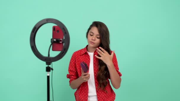 Χαρούμενη έφηβη blogger ομορφιάς χρησιμοποιεί βούρτσα μαλλιών και διαφημίζει τα δυνατά υγιή μαλλιά της, περιποίηση μαλλιών — Αρχείο Βίντεο