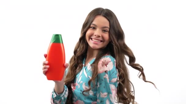 Dítě dívka s úsměvem a otáčení držet vlasy hedvábí láhev ukazující palec nahoru, krása. — Stock video