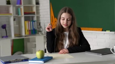 Düşünen kız sınıfta ödev yazıyor, okula geri dönüyor.