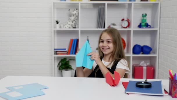 Kul tid av glad tonåring flicka att ha kul med papper plan i skolan lektion i klassrummet, positivitet. — Stockvideo