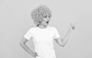 Şuraya bak. Şaşaalı parti bakışı. Palyaço peruklu ucube kadın parmakla işaret ediyor, boşluğu kopyala