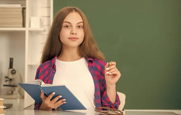 Een lachend kind dat aantekeningen maakt in het notitieboekje. terug naar school. tiener meisje klaar om te studeren. — Stockfoto