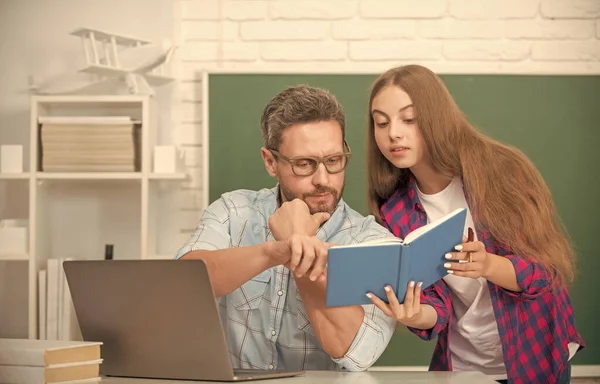 Soukromý učitel a dítě drží sešity. Rodinná pomoc. táta a dcera používají zápisník. — Stock fotografie
