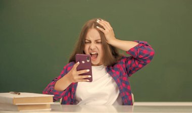 Sınıfta akıllı telefondan konuşan hayret verici çocuk, e-posta cevabı.