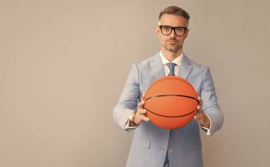 Yakışıklı adam basketbol topunu gri arka planda tut, fotokopi alanı, iş yeri