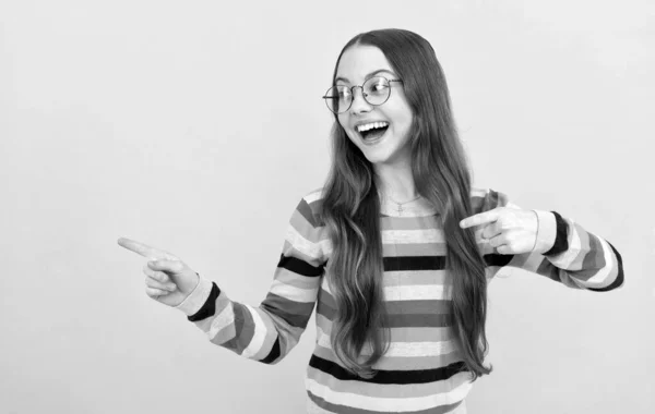 행복 한 똑똑 한 아이야. 안경을 쓴 십 대 소녀가 손가락을 가리키고 있다. 시각의 예리 함. 시력. — 스톡 사진