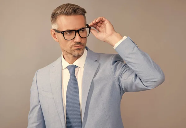 Hombre de éxito en traje de negocios y gafas sobre fondo gris, éxito — Foto de Stock