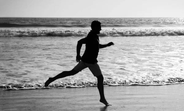 Poranny trening. Sportowiec biegający po plaży. Energiczne lato. biegacz czuje wolność — Zdjęcie stockowe